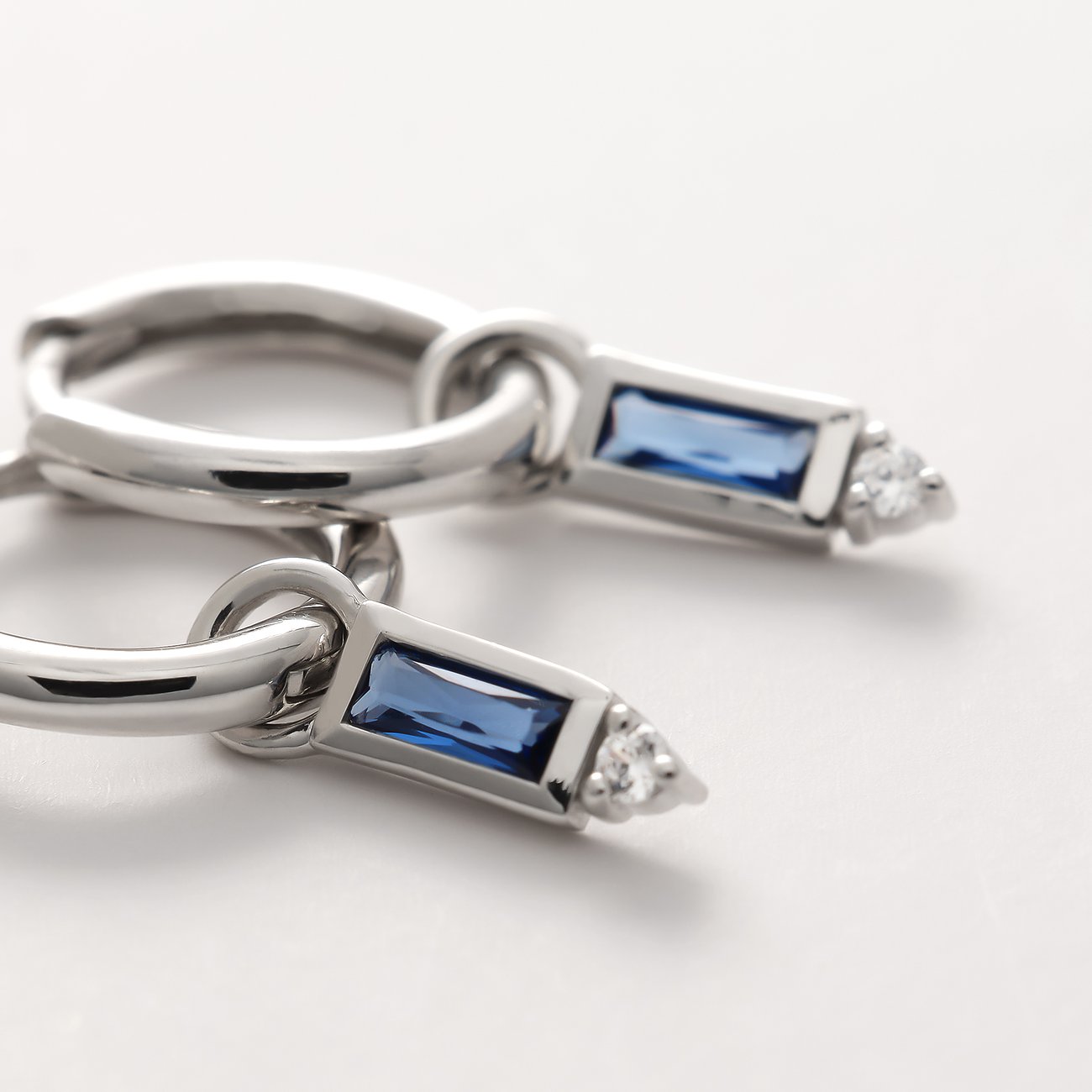 Un paio di orecchini Guido Maria Kretschmer in argento 925 riciclato, con pietre di zirconia blu rettangolari.