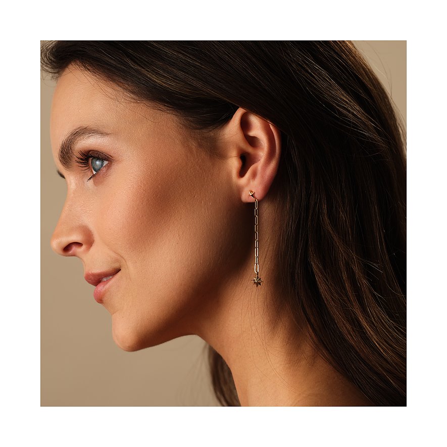 Close-up einer Frau, die Guido Maria Kretschmer Ohrschmuck aus recyceltem 925er Silber in Goldoptik trägt.