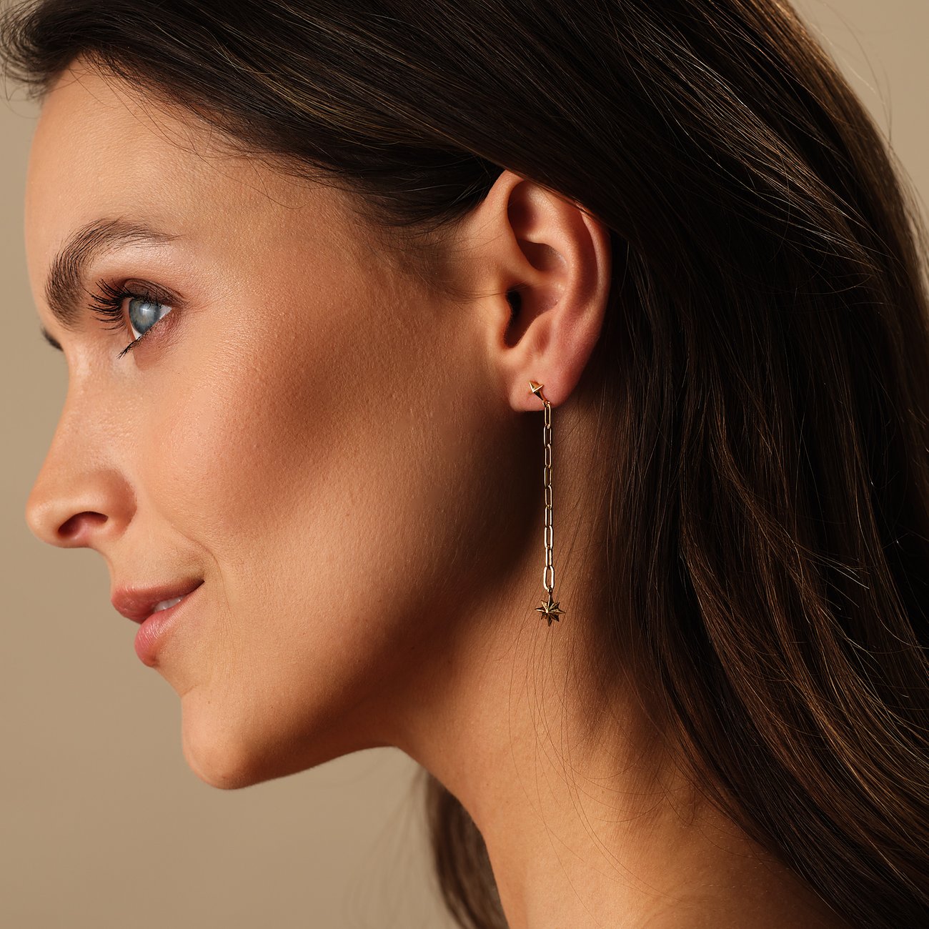 Close-up einer Frau, die Guido Maria Kretschmer Ohrschmuck aus recyceltem 925er Silber in Goldoptik trägt.