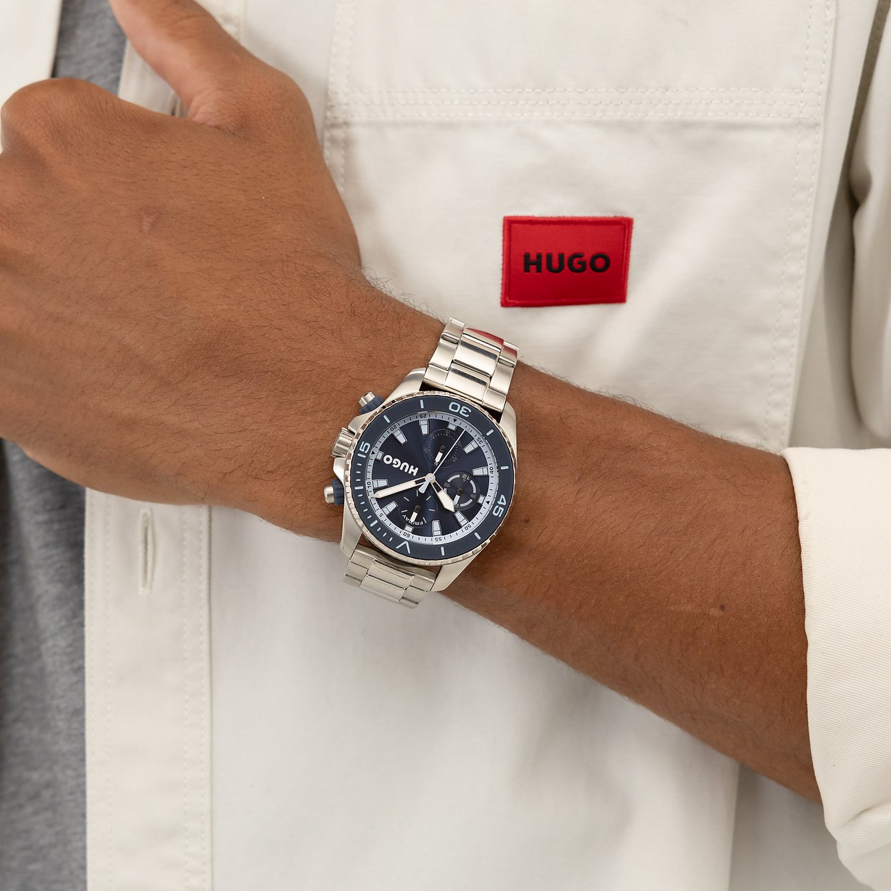 Hugo herenhorloge van roestvrij staal gedragen om de pols, met marineblauw wijzerblad en chronograaffuncties.