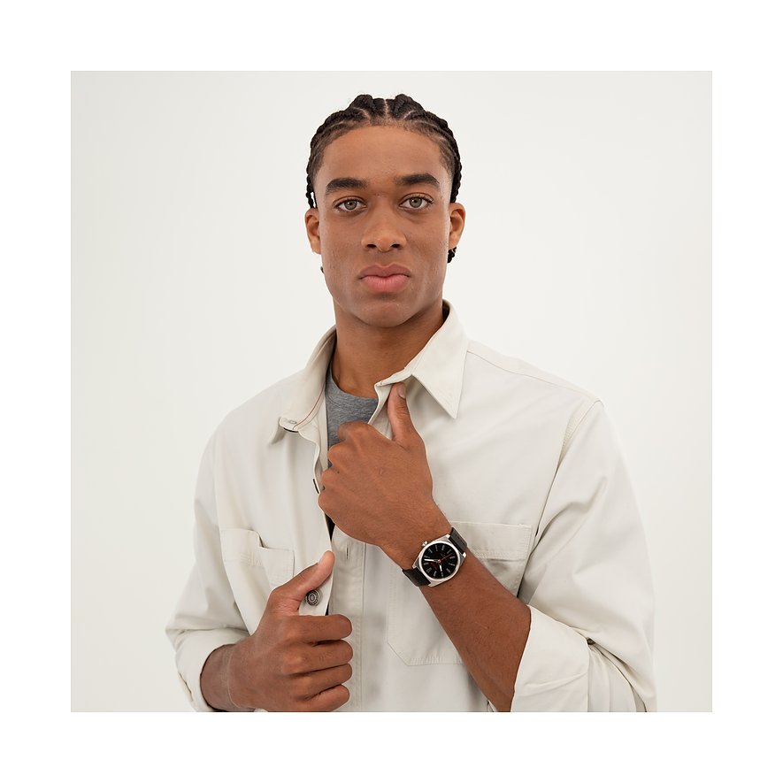Ein Mannequin präsentiert eine HUGO Herrenuhr aus Edelstahl mit dunklem Zifferblatt und schwarzem Armband.