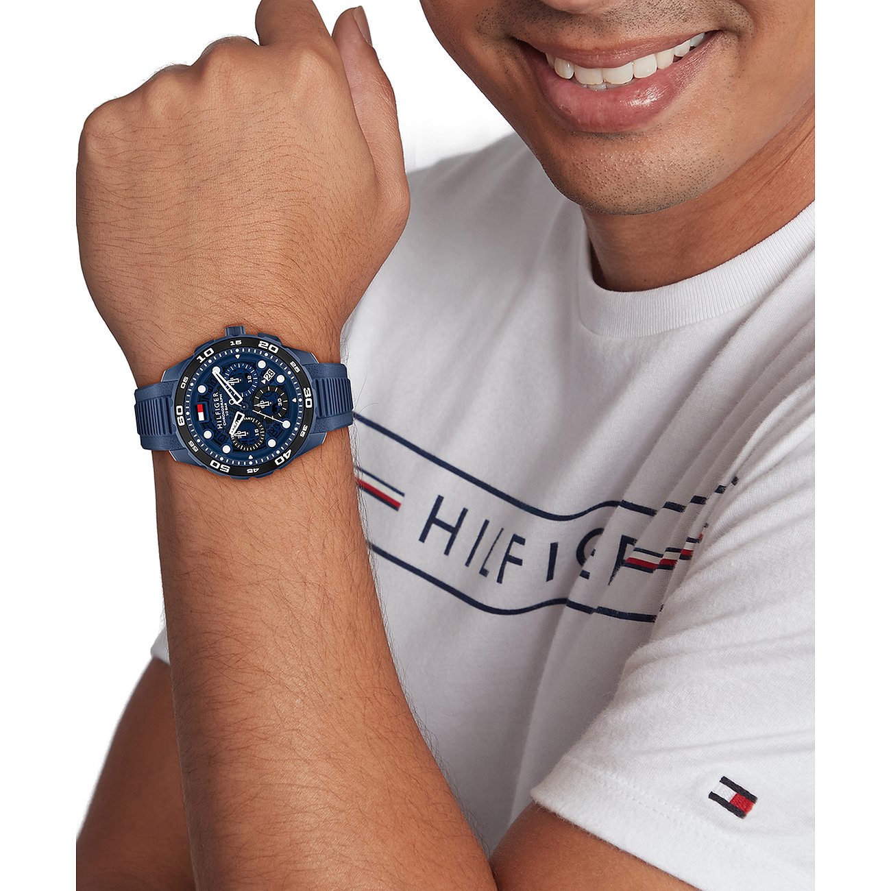 Nahaufnahme einer Tommy Hilfiger Herrenuhr aus dunkelblauem Edelstahl und Aluminium am Handgelenk eines Mannes.