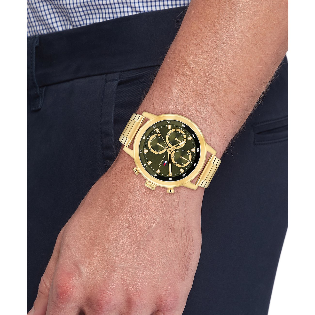Goudkleurig roestvrijstalen Tommy Hilfiger herenhorloge met donkere wijzerplaat, gedragen om de pols.