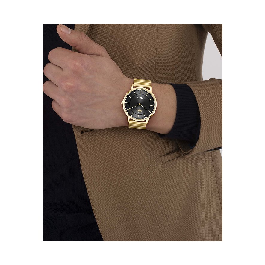 Am Handgelenk eines Mannes getragene goldene Lacoste Herrenuhr aus Edelstahl mit schwarzem Zifferblatt.
