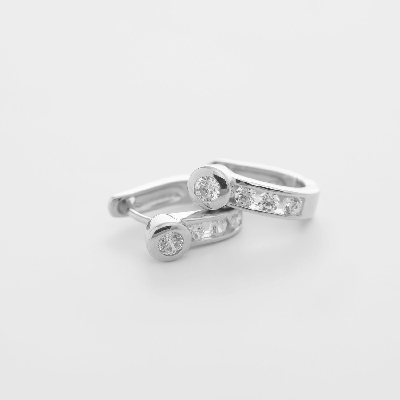 Ein Paar Ohrschmuck von CHRIST aus Gelbgold 585 mit Diamanten, eine Creole mit fünf Diamanten pro Ohrring, frontal.