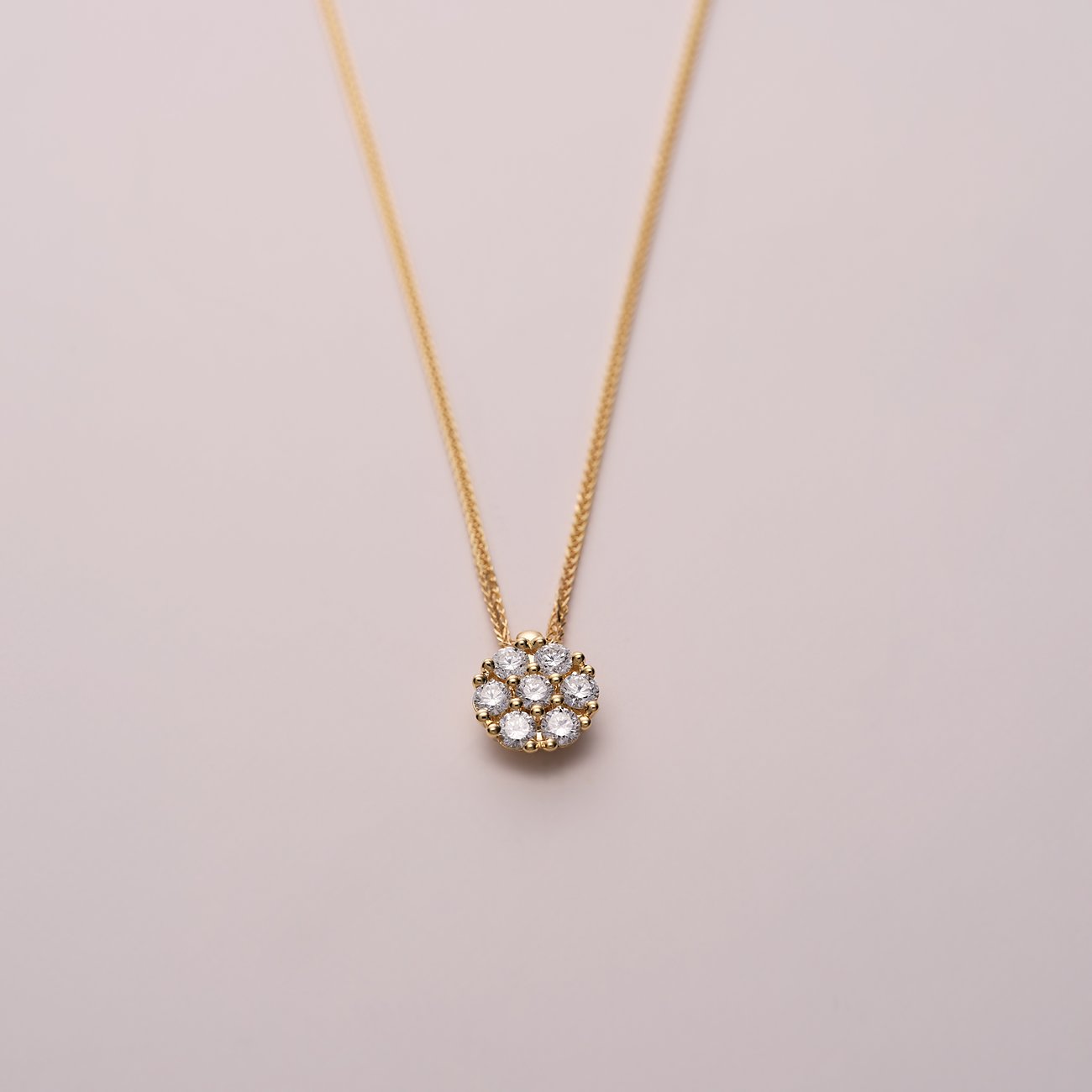 CHRIST Halsschmuck aus 585 Gelbgold mit sieben funkelnden Diamanten, die eine runde Blumenform bilden.