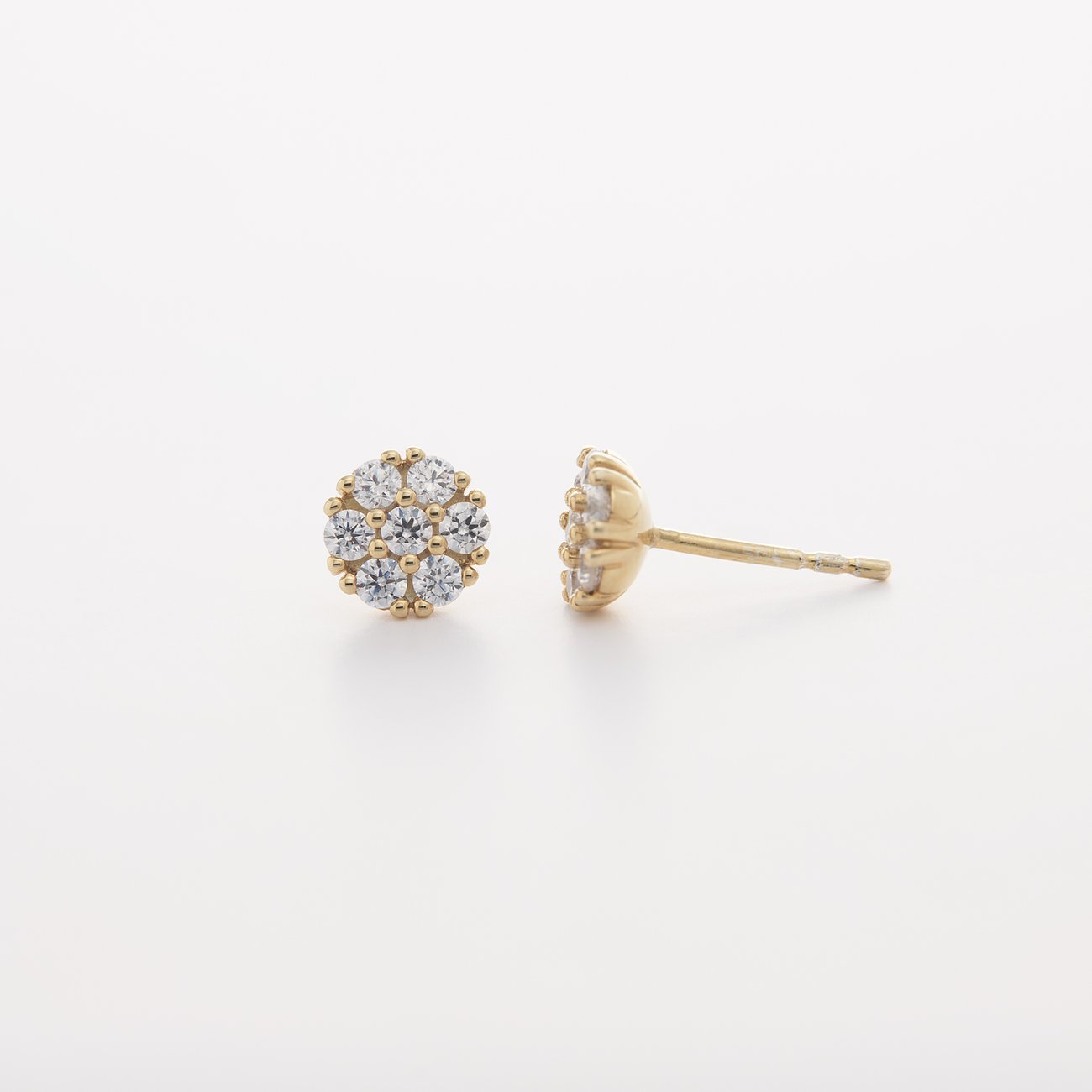 Nahaufnahme der CHRIST Ohrstecker aus Gelbgold. Sieben funkelnde Diamanten pro Ohrring bilden eine Blume.