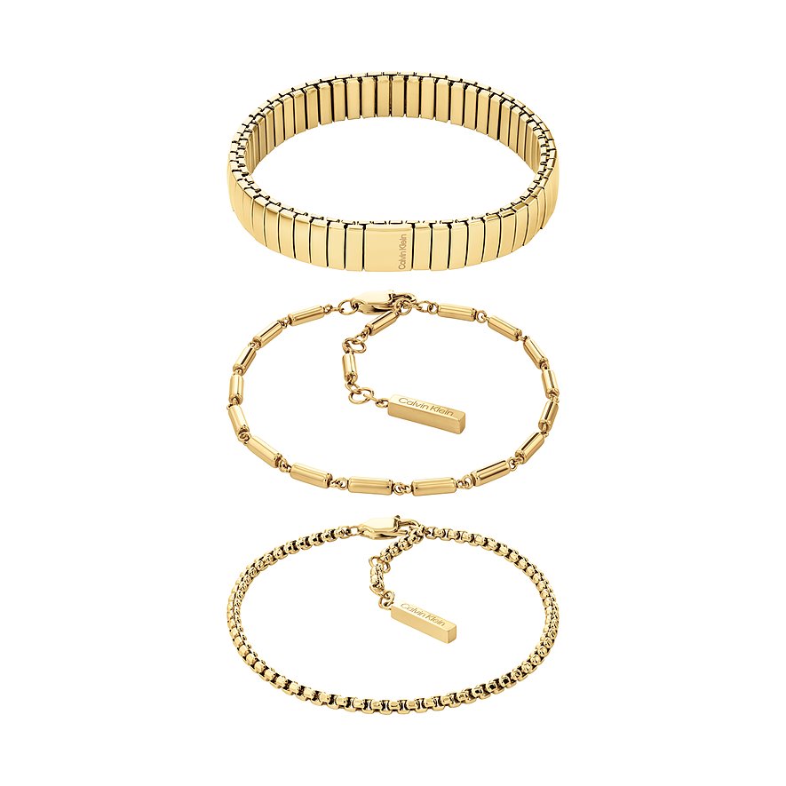 Drei goldfarbene Calvin Klein Armbänder aus Edelstahl in verschiedenen Designs sind übereinander angeordnet.