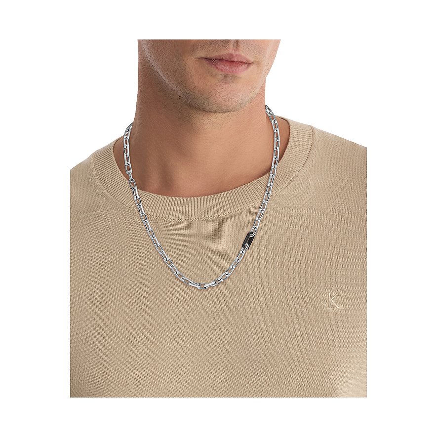 Nahaufnahme eines Mannes, der eine Calvin Klein Halskette aus Edelstahl trägt, wobei die Kette eng am Hals liegt.
