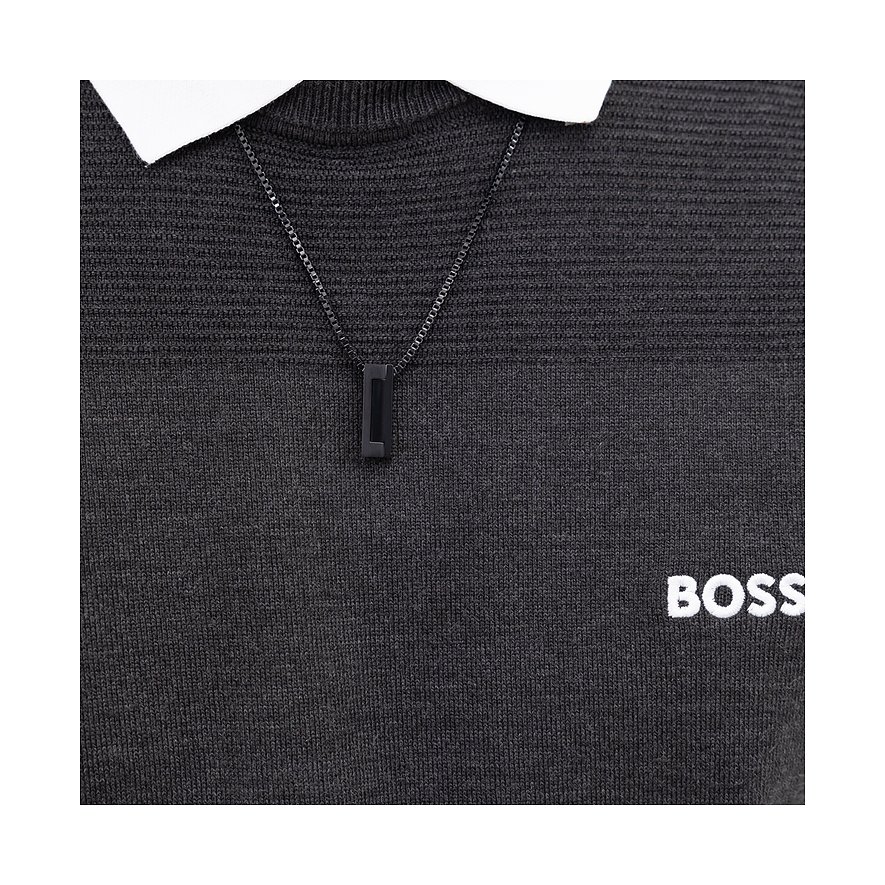Boss ketting van zwart roestvrij staal met rechthoekige hanger, gedragen over een zwarte trui.