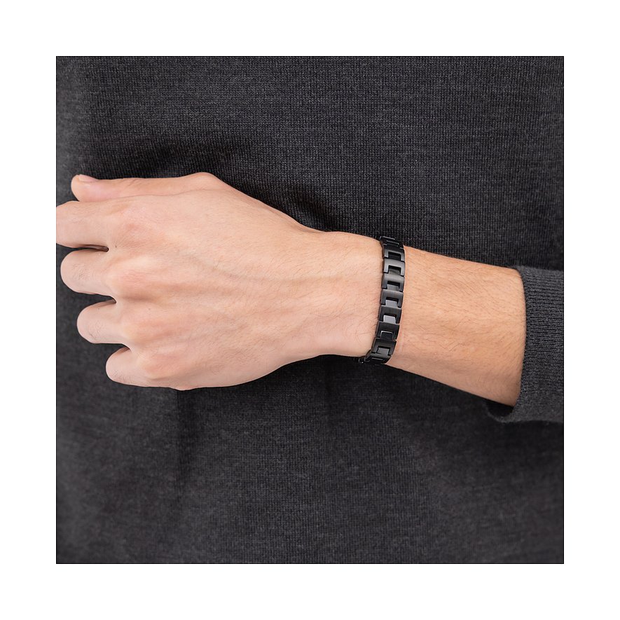 Am Handgelenk eines Mannes sitzt ein Boss-Armband aus schwarzem Edelstahl mit glatten Gliedern.