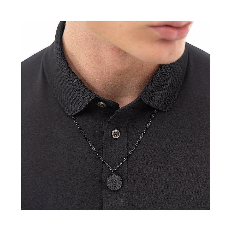 Nauwe detailpersoon draagt een Boss ketting van roestvrij staal met een ronde, donkere hanger.