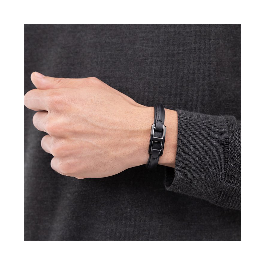Zwarte Boss leren armband, gedragen om de pols, met een donkere, smalle gespsluiting.