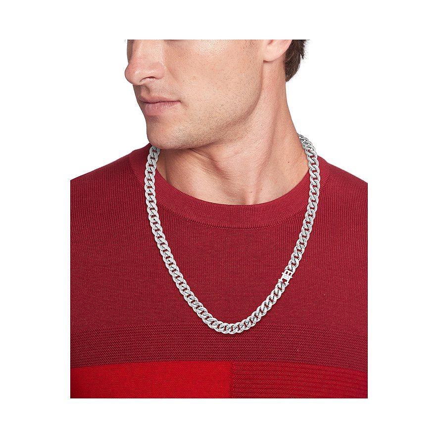 Ein Mann im roten Pullover trägt eine glänzende, silberfarbene Tommy Hilfiger Halskette aus Edelstahl.