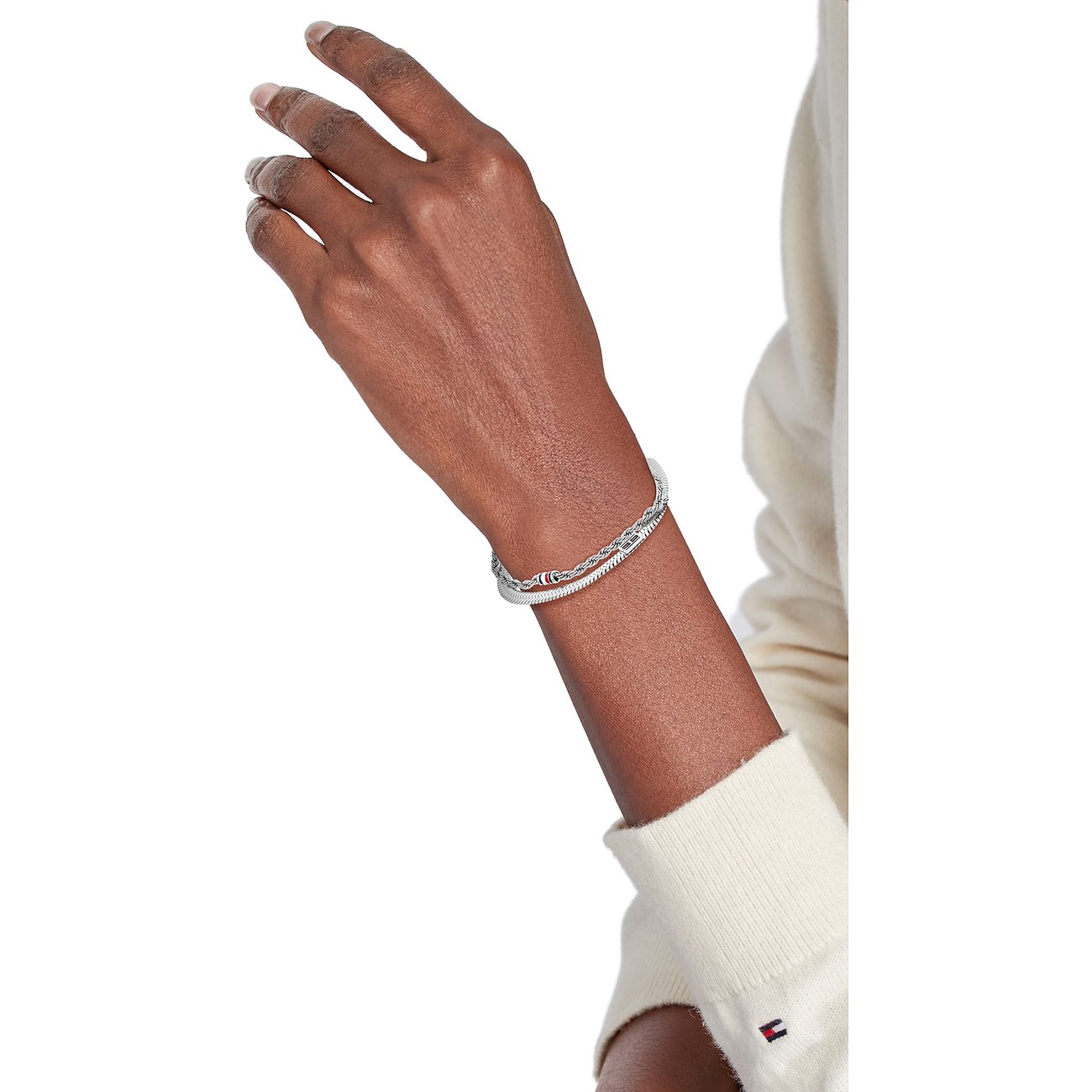 Am Handgelenk getragenes, silberfarbenes Tommy Hilfiger Edelstahl-Armband mit zwei Ketten, die eine in Kordeloptik.