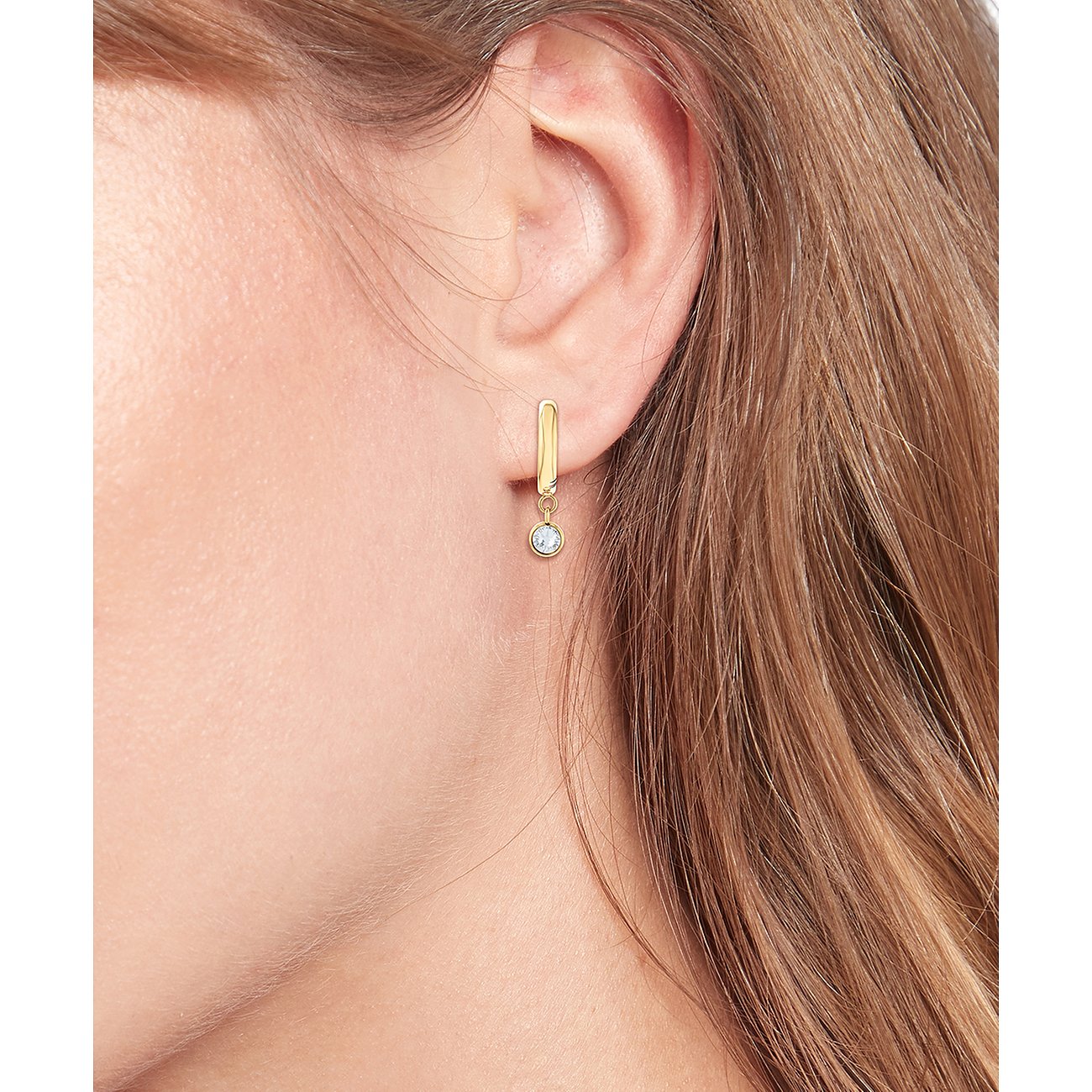 Tommy Hilfiger Ohrschmuck aus gelb vergoldetem Edelstahl mit hängendem, klarem Schmuckstein.