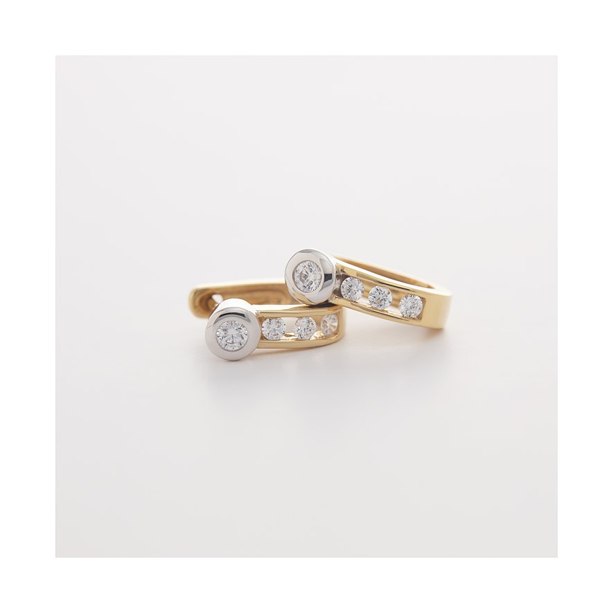 CHRIST Ohrschmuck aus Gelb- und Weißgold 585 mit mehreren glänzenden Diamanten, nah aufgenommen.