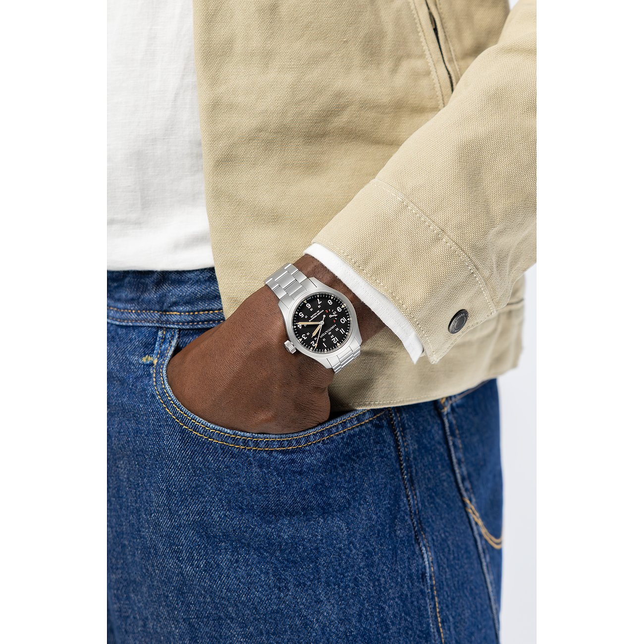 Am Handgelenk eines Mannes getragene Hamilton Herrenuhr aus Edelstahl mit analogem Zifferblatt und silberfarbenem Armband.