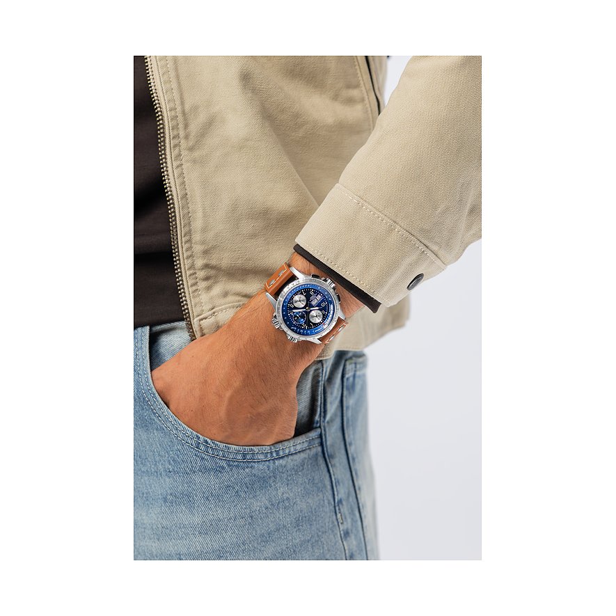 Am Handgelenk eines Mannes Hamilton Herrenuhr aus blauem Edelstahl mit braunem Lederband, Hand in Hosentasche.