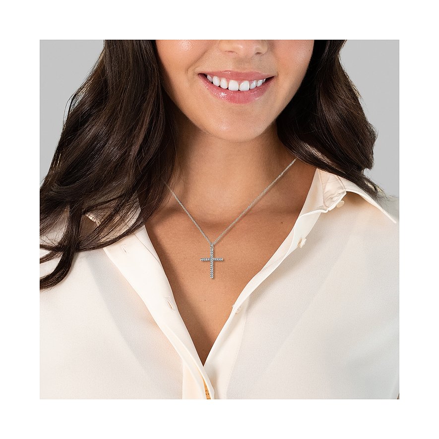 Eine Frau trägt eine Glanzstücke München Halskette aus Silber mit einem schlichten, länglichen Kreuzanhänger.