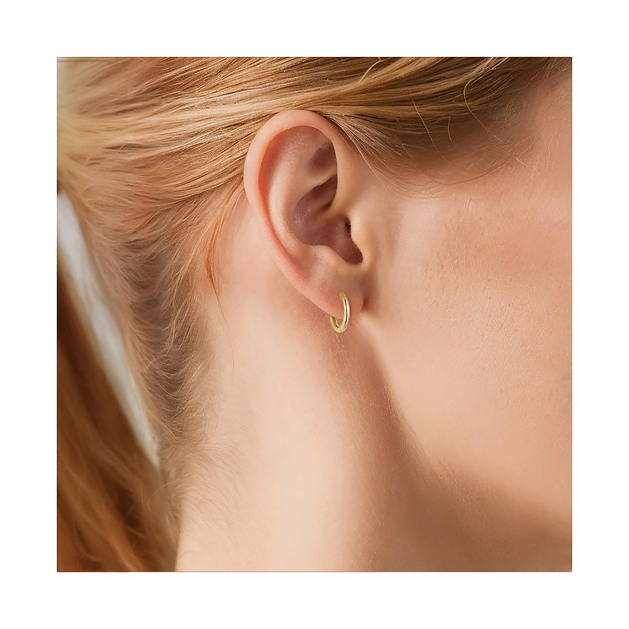 Ein glänzender, goldfarbener Ohrring aus 925er Silber von Glanzstücke München, getragen an einem Ohr.