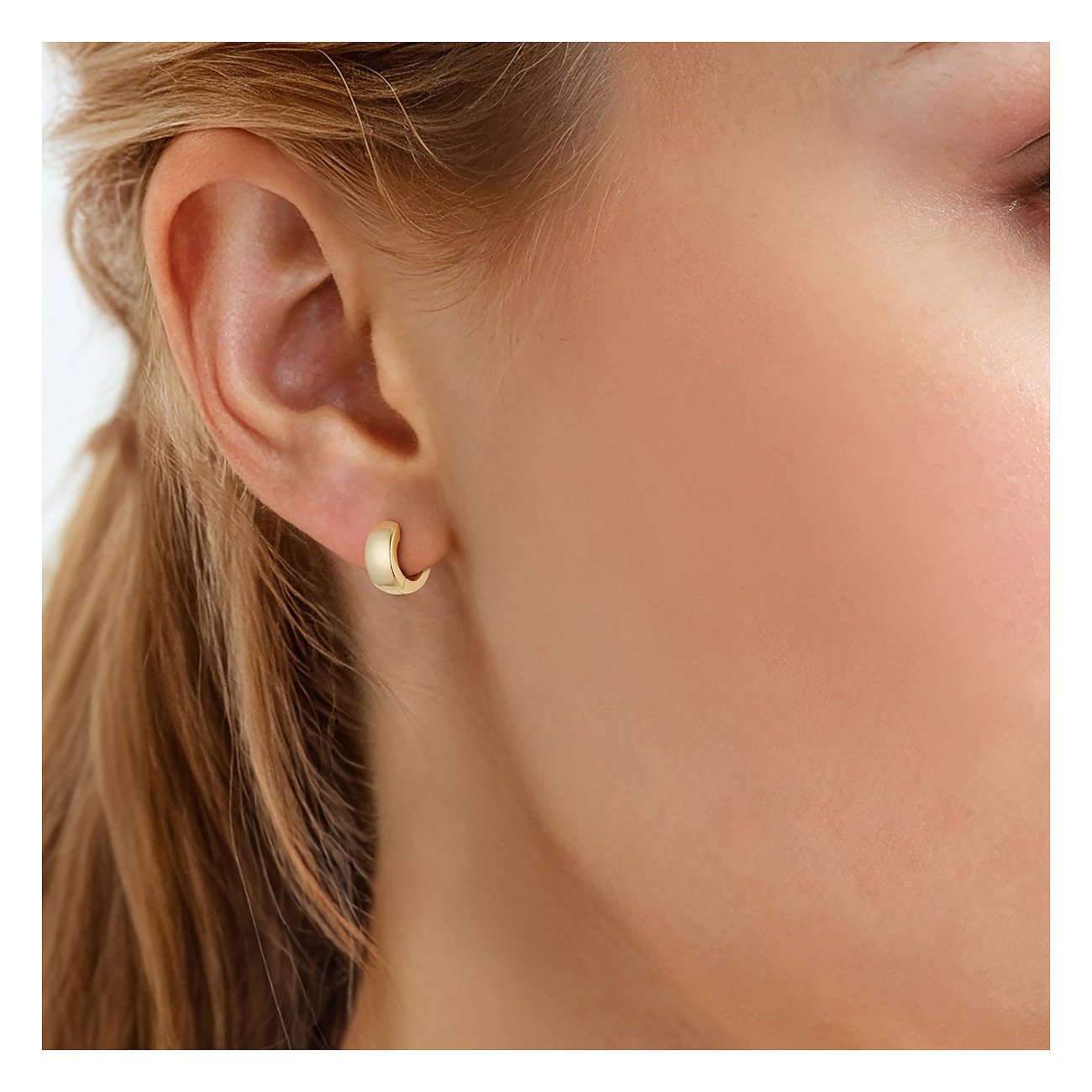 Am Ohr getragener Glanzstücke München Ohrschmuck aus vergoldetem 925er Silber in Form kleiner, matter Creolen.