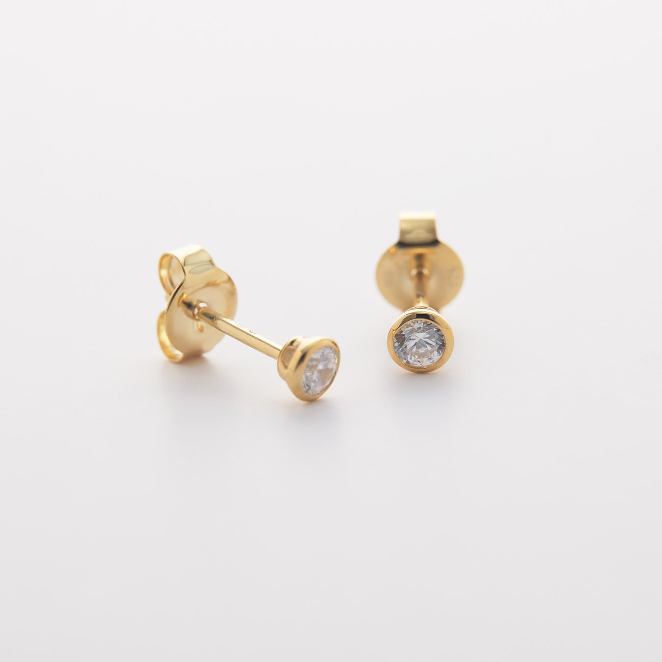 CHRIST Ohrschmuck aus 585 Gelbgold mit Diamanten, eine Draufsicht, wobei ein Ohrstecker etwas gekippt ist.