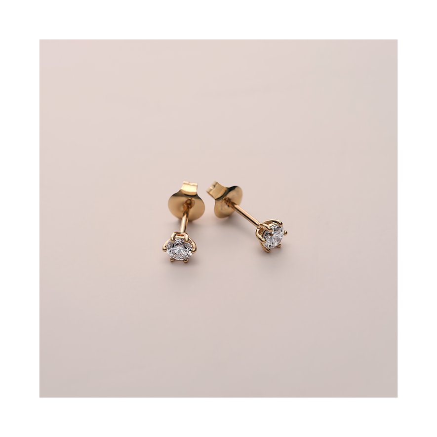 Ein Paar CHRIST Ohrstecker aus 585 Gelbgold mit funkelnden Diamanten, schräg liegend auf hellem Grund.