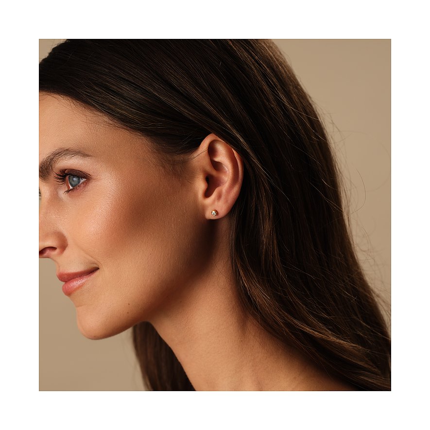 Nahaufnahme einer Frau im Profil, die einen einzelnen runden CHRIST Weißgold-Ohrstecker mit Diamant trägt.