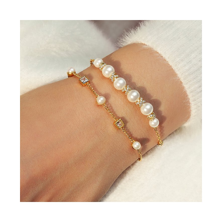 Ania Haie Armschmuck aus vergoldetem Silber mit weißen Perlen und Zirkonia in einer Nahaufnahme an einem Handgelenk.