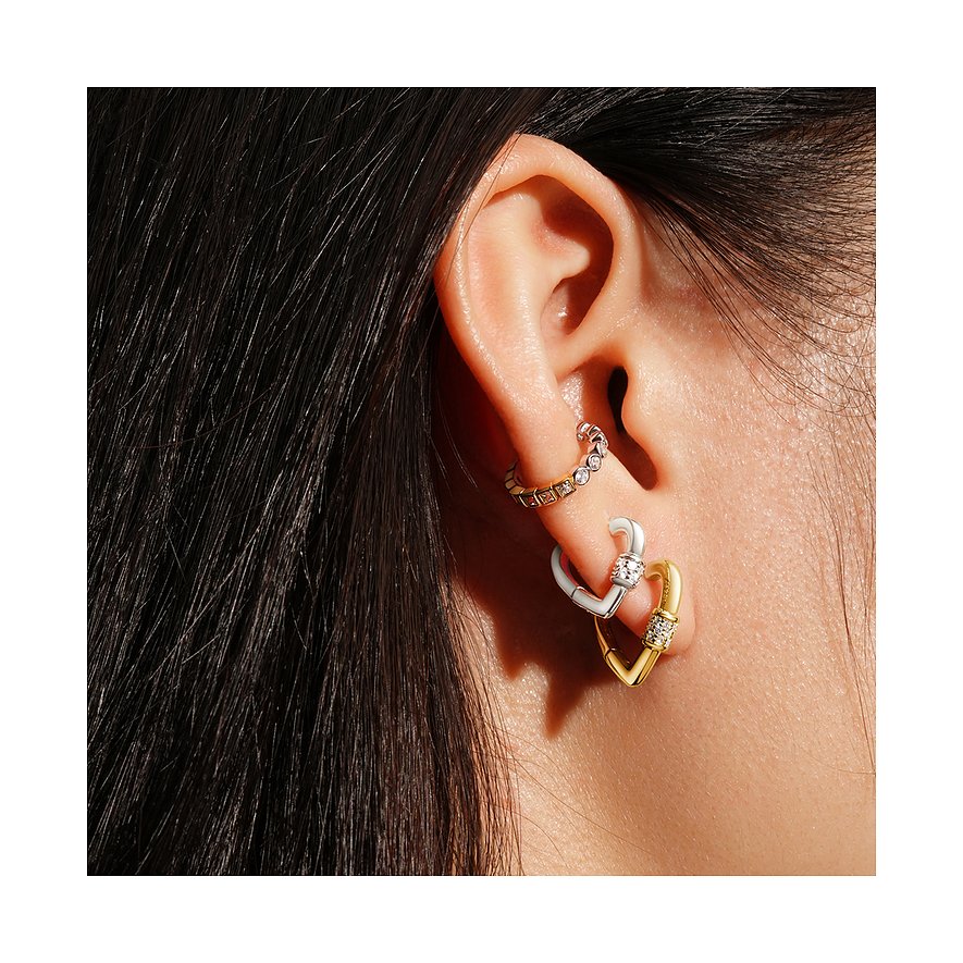 Bijoux d'oreille Ania Haie en argent : Un ear cuff Ania Haie doré et un argenté pendent ensemble à l'oreille.