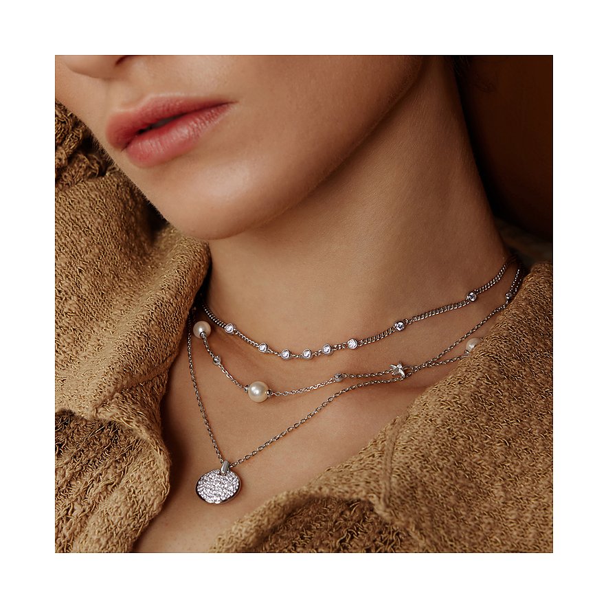 Close-up van vrouw met een drielaags zilveren Ania Haie halsketting, versierd met zirkonia en parels.