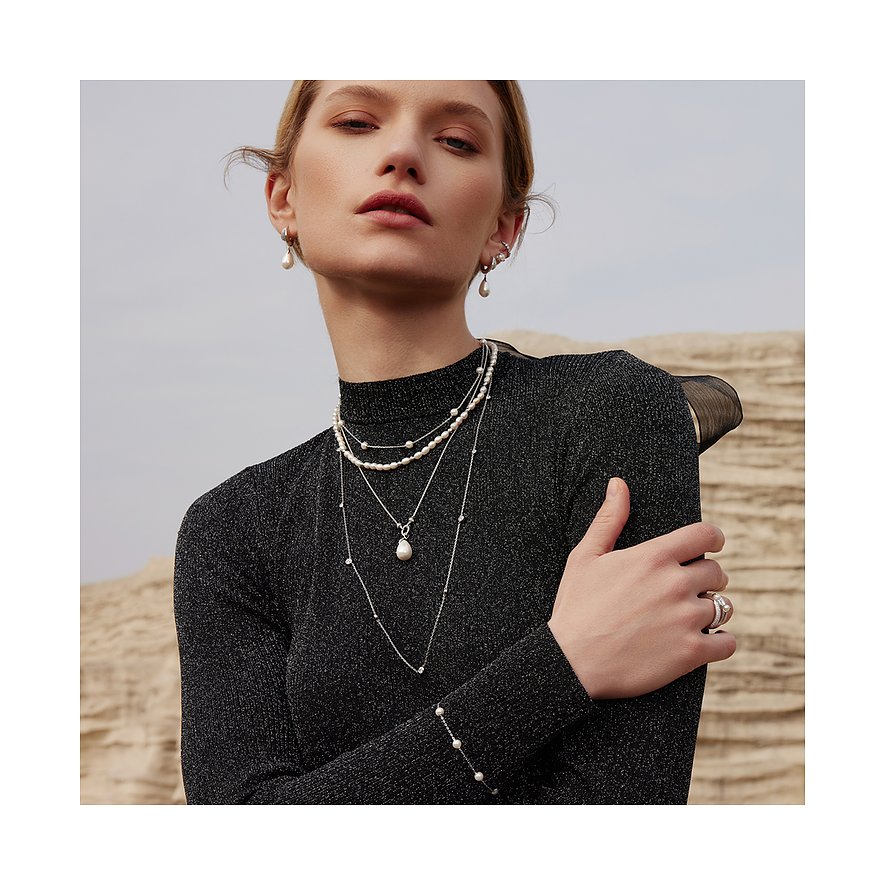 Model draagt een gestapelde Ania Haie ketting van 925 zilver, met zirkonia en parelhangers.