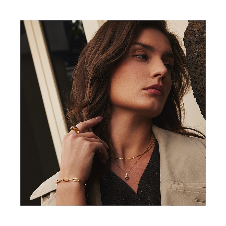 Een vrouw draagt een vergulde Ania Haie 925 zilveren ketting met een zirconia edelsteen.