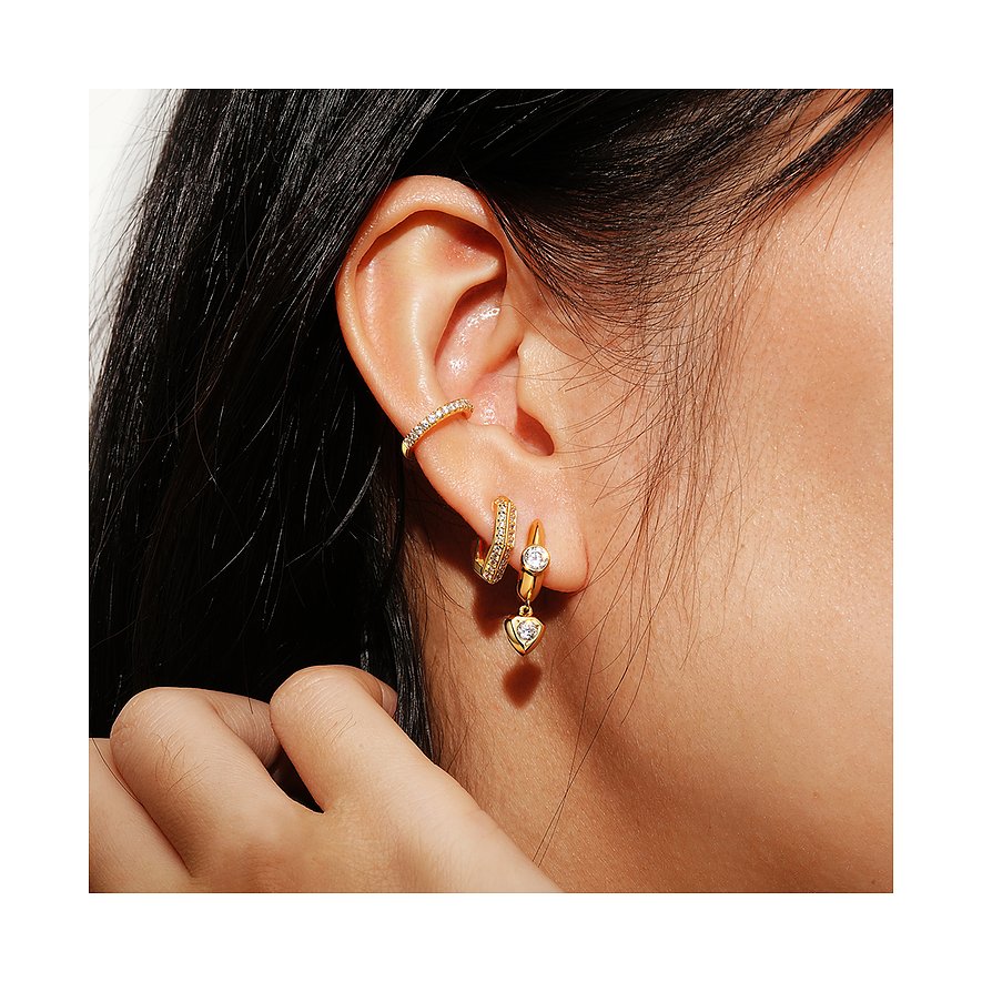 Des boucles d'oreilles Ania Haie en argent plaqué or avec zircone sont portées par une personne aux cheveux foncés.
