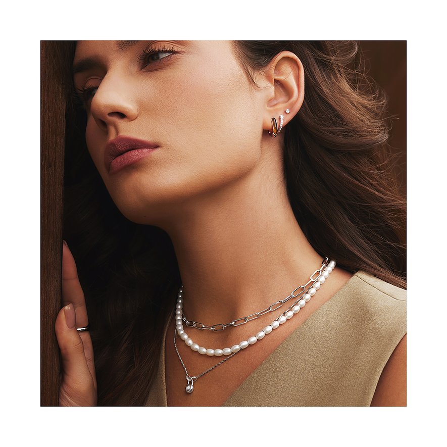 Close-up van vrouw met een Ania Haie zilveren multi-rijige halskettingset, inclusief een parelketting.