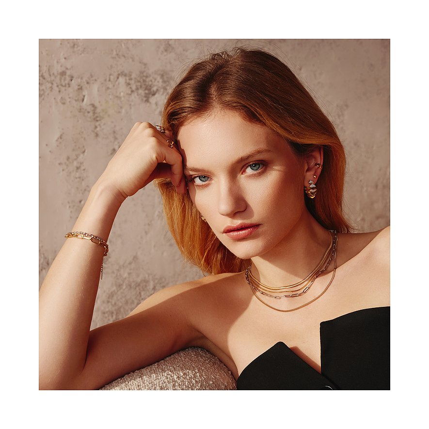 Model draagt een Ania Haie zilveren halsketting. Ze draagt ook een bijpassende armband en oorbellen.