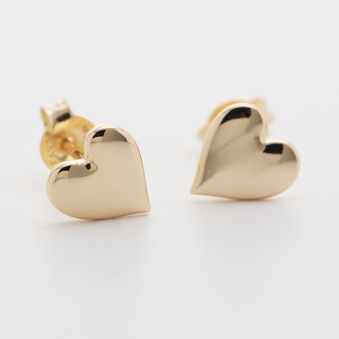 FAVS Ohrschmuck: Glänzende goldfarbene Herzohrstecker aus 925 Silber, leicht nach links gedreht auf weißem Untergrund.