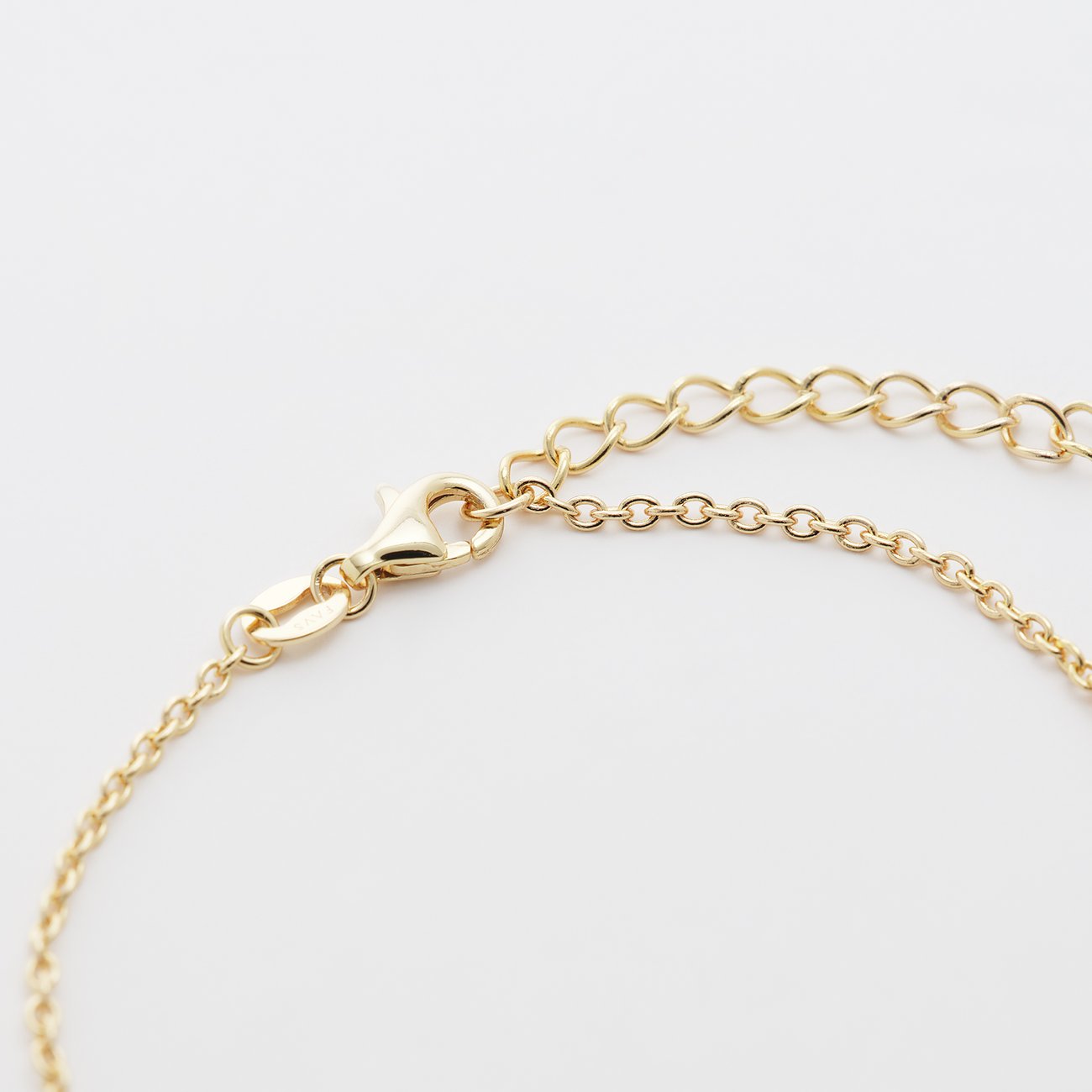 Gros plan du fermoir d'un bracelet FAVS en argent sterling 925 plaqué or, avec œillets d'ajustement.