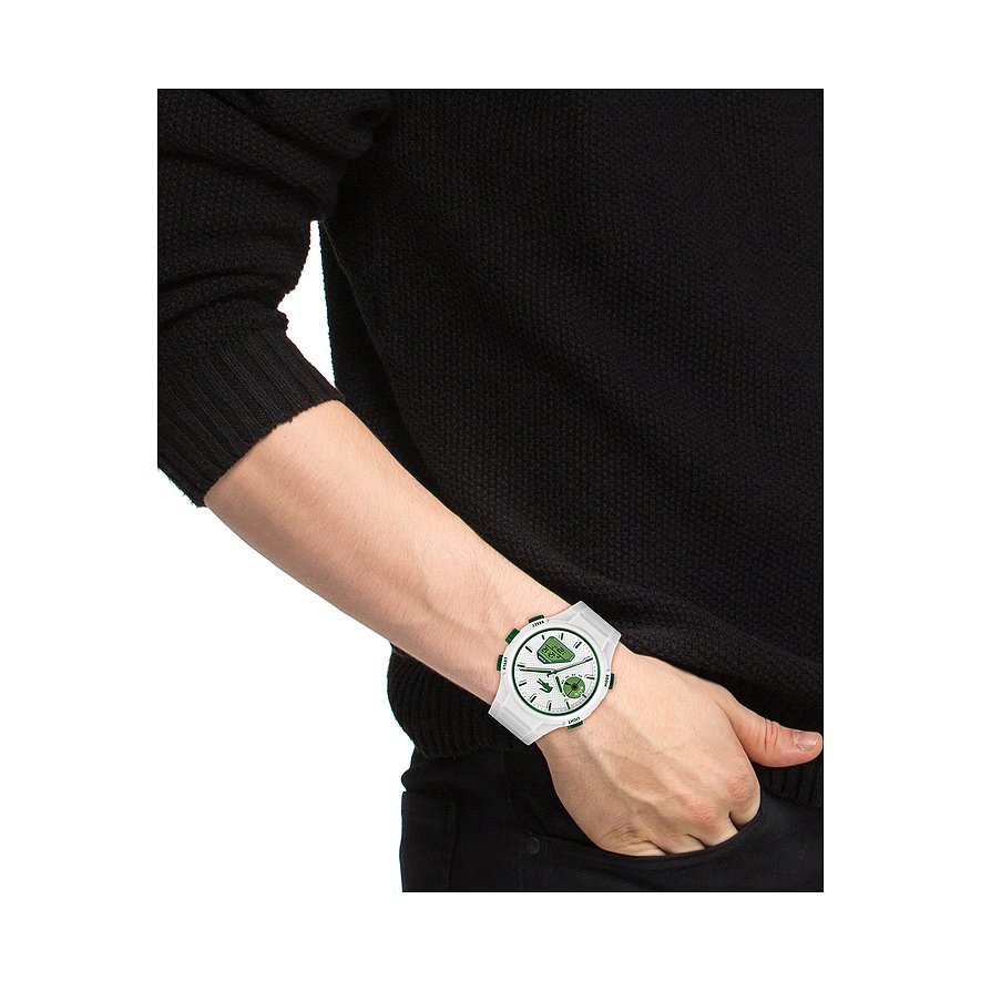 Am Handgelenk eines Mannes getragene weiße Lacoste Herrenuhr aus Kunststoff mit grünen Akzenten und Edelstahl-Details.