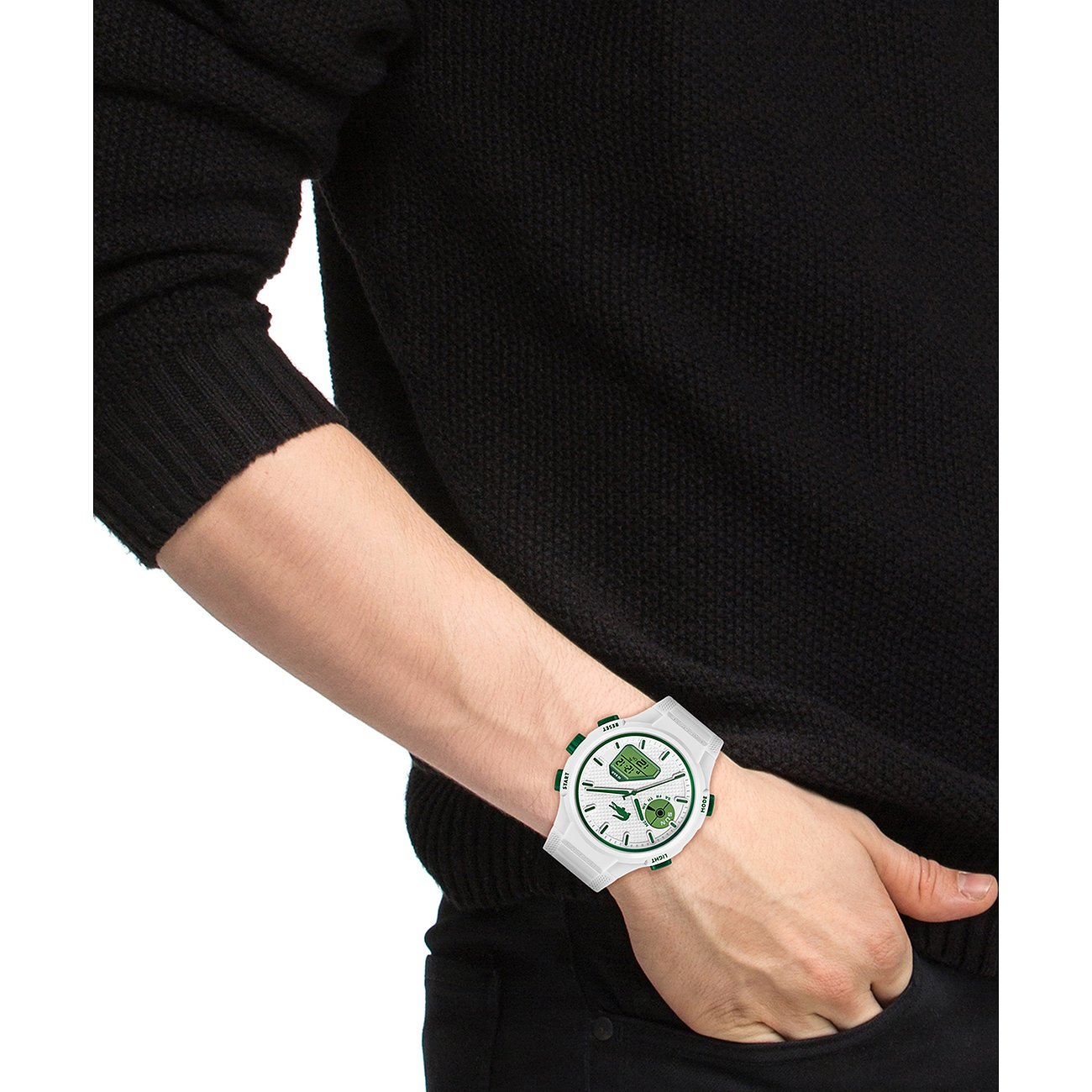 Am Handgelenk eines Mannes getragene weiße Lacoste Herrenuhr aus Kunststoff mit grünen Akzenten und Edelstahl-Details.