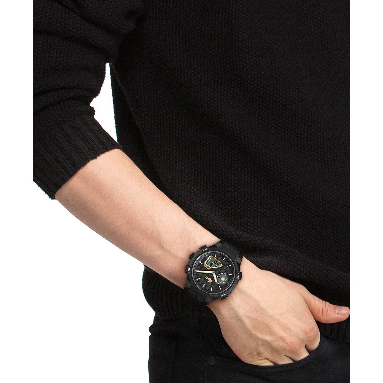 Am Handgelenk eines Mannes getragen: Eine schwarze Edelstahl-Herrenuhr von Lacoste mit digitaler Anzeige.