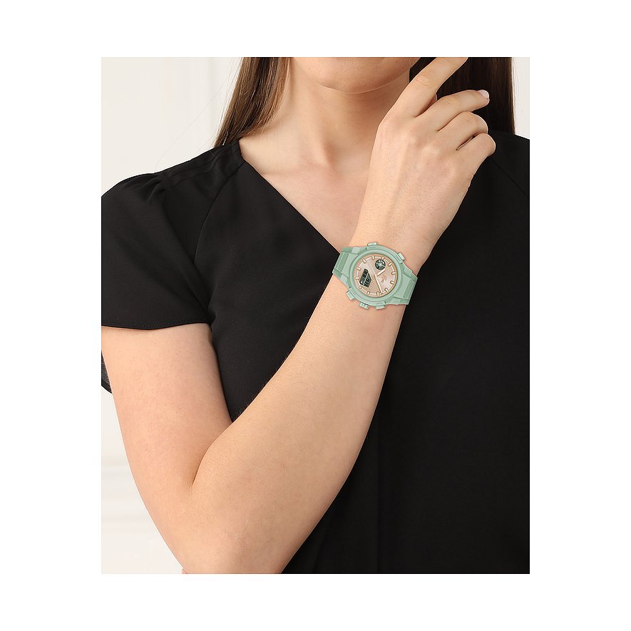 Eine Frau trägt eine Damenuhr von Lacoste aus Kunststoff und Edelstahl in Mintgrün am rechten Handgelenk.