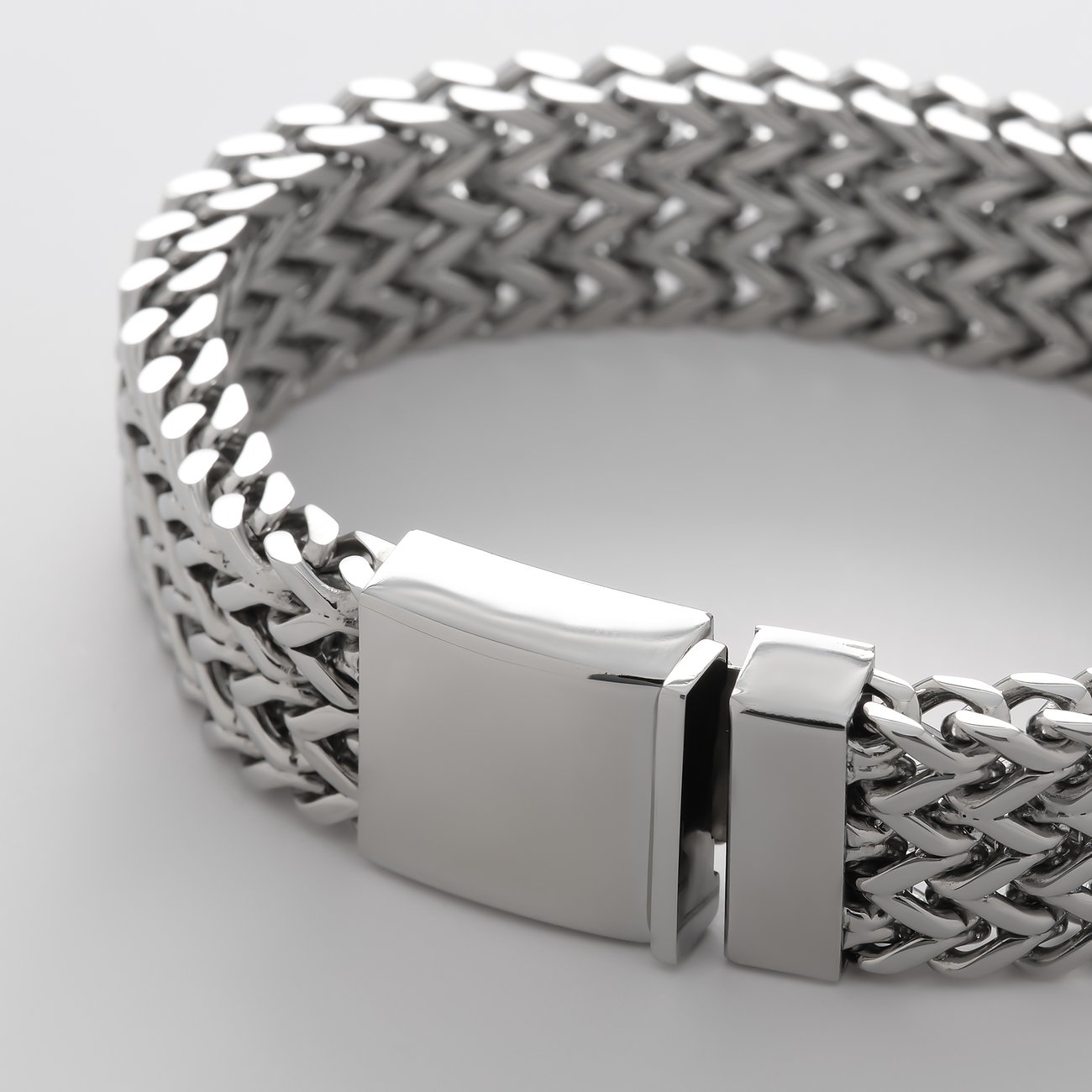 FAVS Edelstahl Armschmuck mit glänzendem Verschluss und geflochtenen Gliedern in Nahaufnahme.