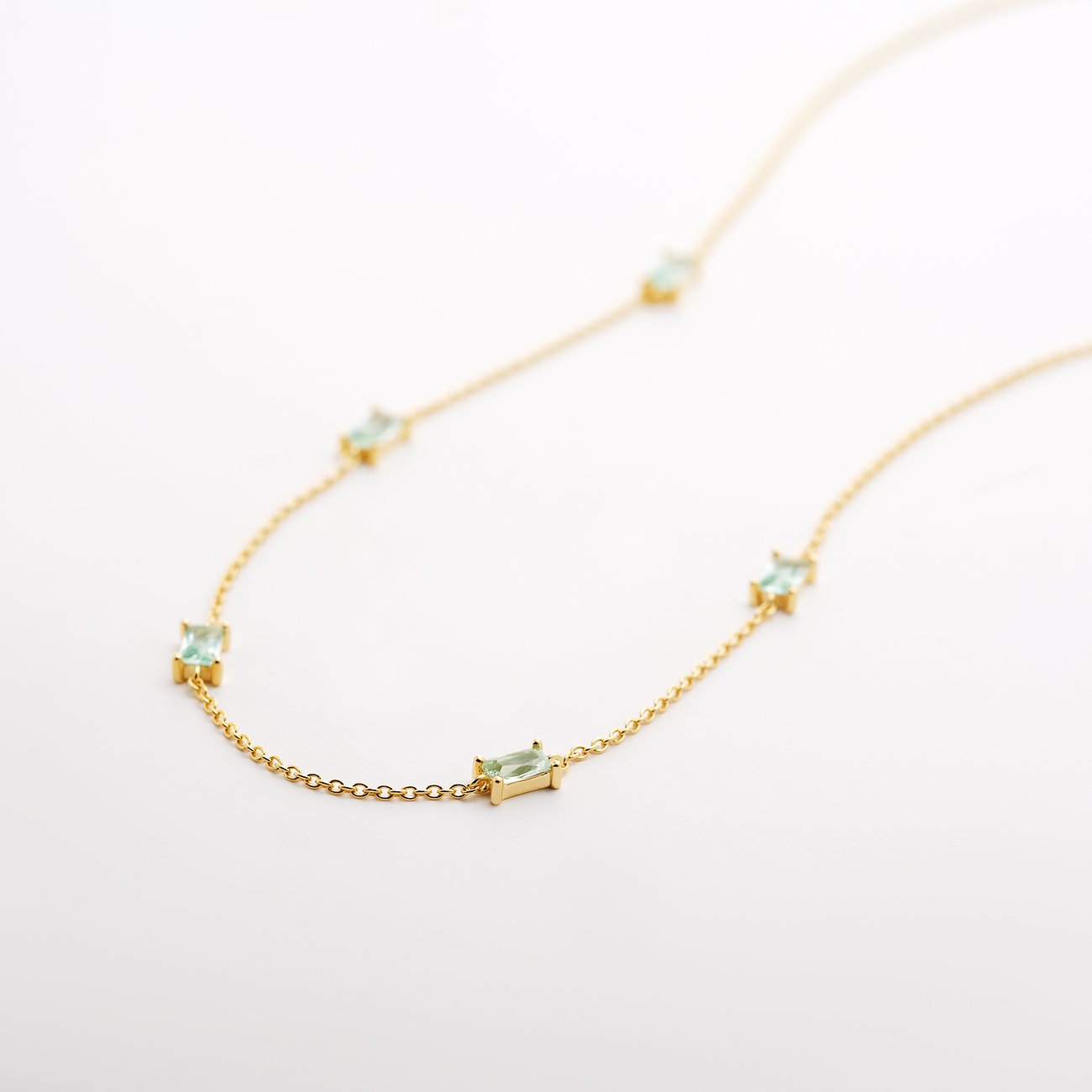 CHRIST ketting: gerecycled zilver, lichtgroene rechthoekige zirkonia-elementen op elegante gouden ketting.