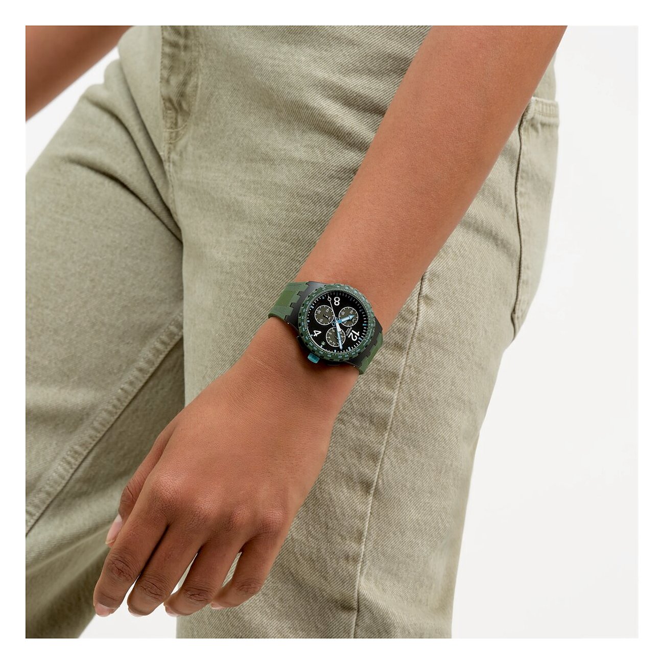 Dettaglio Swatch unisex in plastica verde scuro, indossato al polso, quadrante mostrato da vicino.