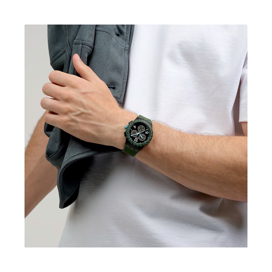Orologio unisex Swatch in plastica verde scuro con quadrante bianco e nero, indossato al polso di un uomo.
