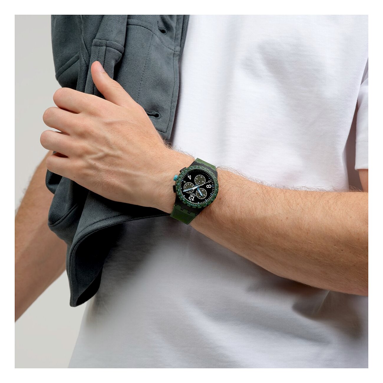 Orologio unisex Swatch in plastica verde scuro con quadrante bianco e nero, indossato al polso di un uomo.