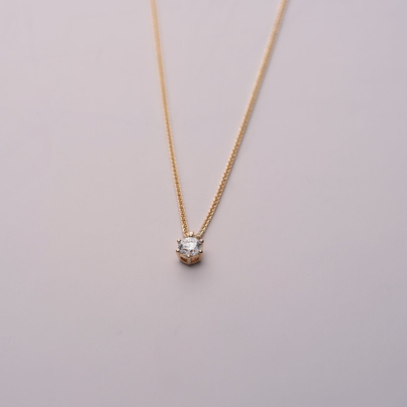 Eine CHRIST Gelbgold 585 Halskette mit einem strahlenden Diamant-Anhänger, auf einem neutralen Hintergrund.