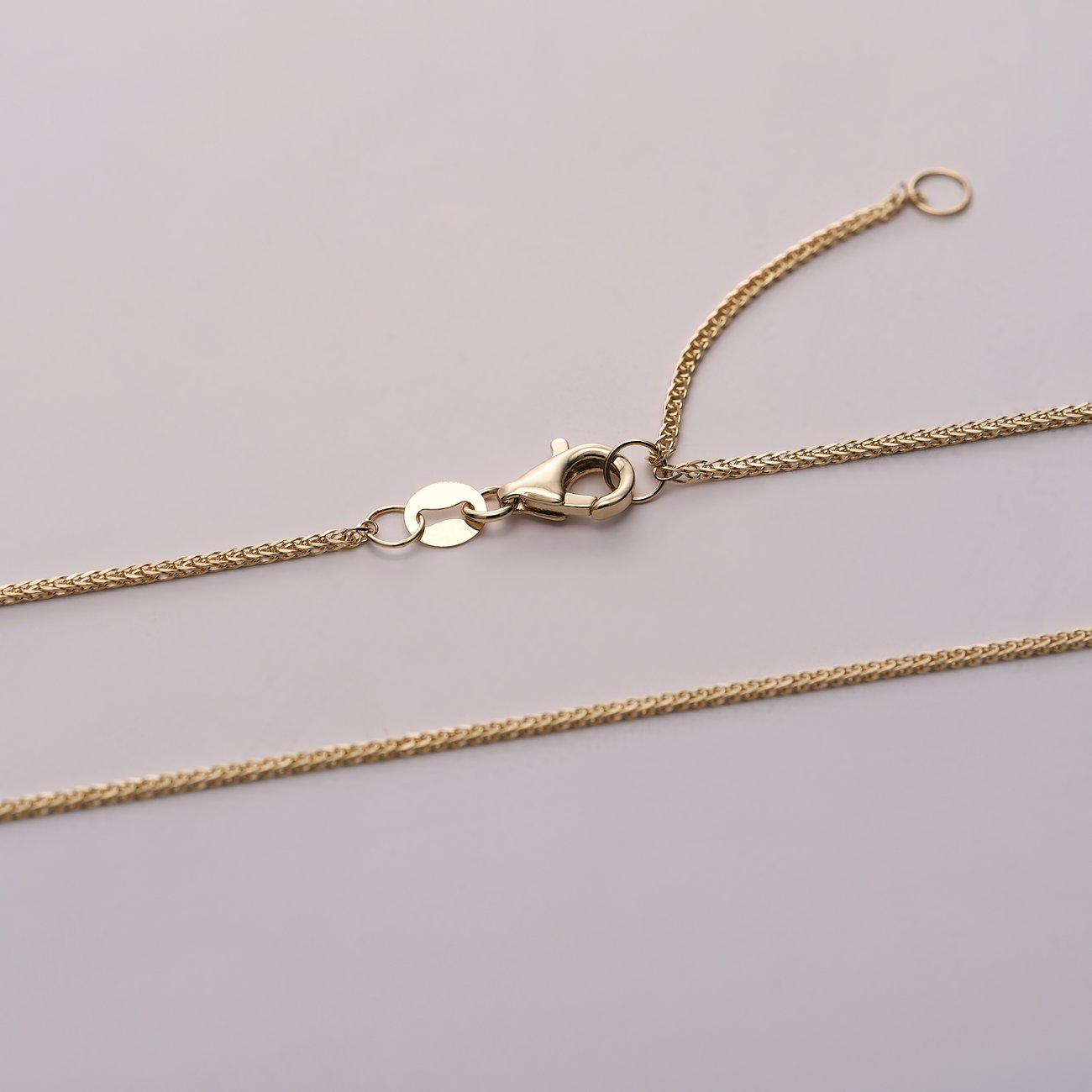 Die goldene Ankerkette aus 585 Gelbgold von CHRIST zeigt ihren Verschluss und das Verlängerungsstück.